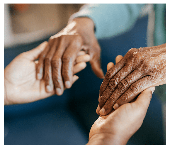 Two pairs of hands gently holding each other, symbolizing care.