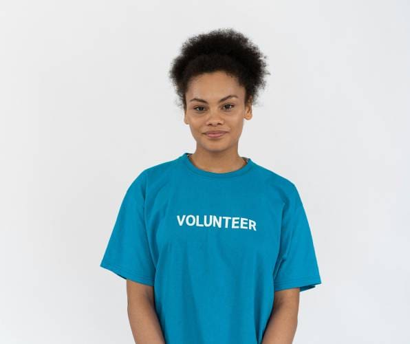Young woman wearing a blue volunteer t-shirt.